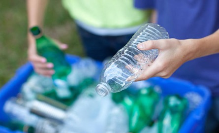 People sorting recyclables into recycling bin